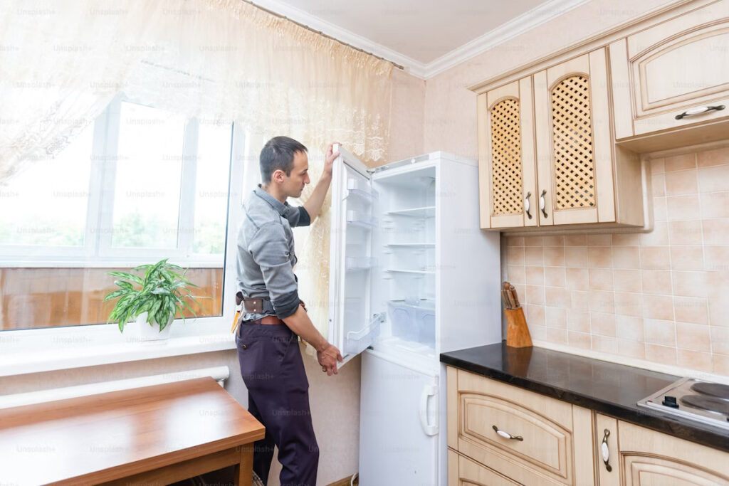 Professional Hitachi appliance repair technician in Karachi fixing a refrigerator